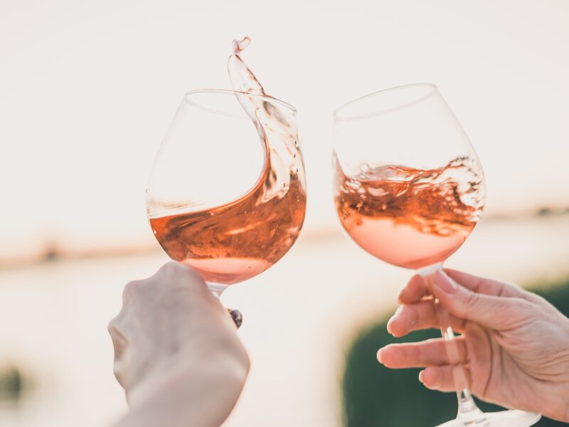 Zwei Weingläser mit Rosewein prosten sich zu